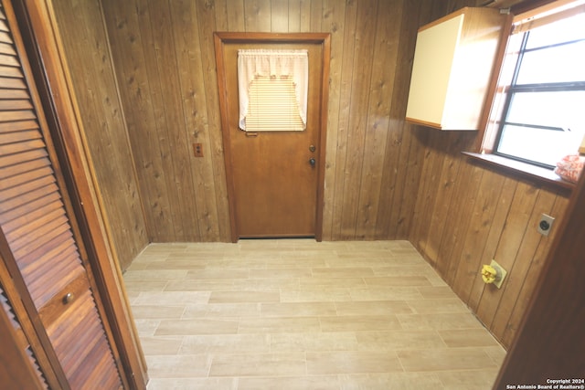 doorway to outside featuring wood walls and light hardwood / wood-style floors