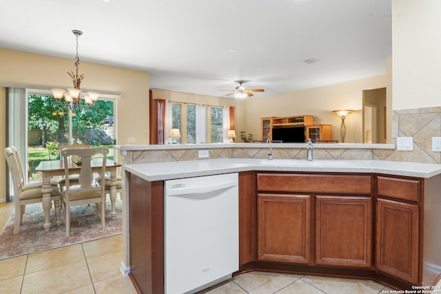 kitchen with white dishwasher, light tile patterned floors, sink, decorative light fixtures, and ceiling fan with notable chandelier