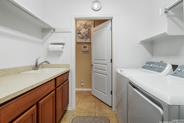 clothes washing area featuring washing machine and clothes dryer, light tile patterned floors, and sink