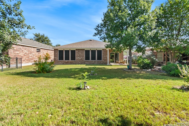 rear view of property featuring a lawn