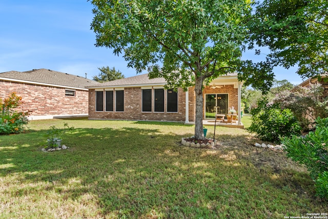 rear view of property featuring a patio and a yard