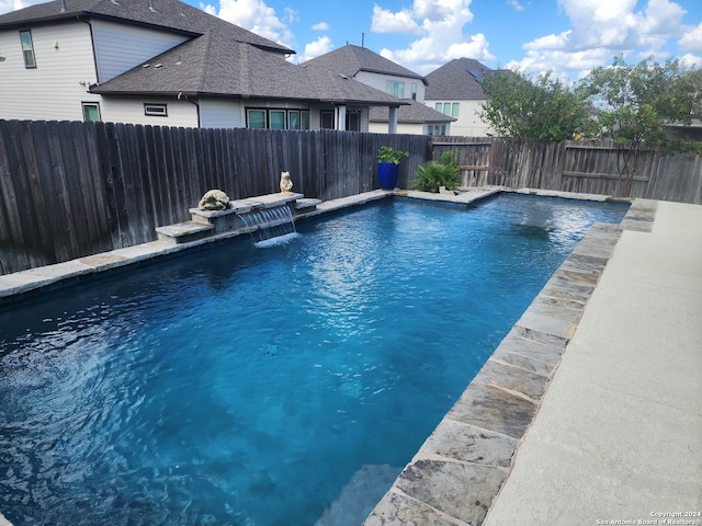 view of swimming pool with pool water feature