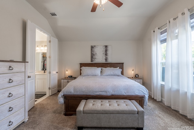 bedroom featuring ceiling fan, light colored carpet, lofted ceiling, and connected bathroom