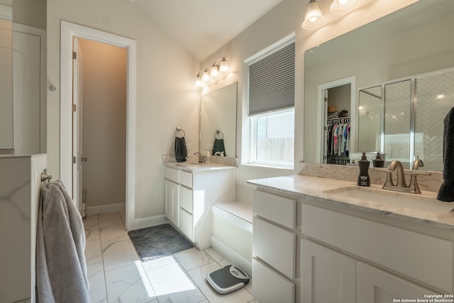 bathroom with vanity, vaulted ceiling, and a shower with door