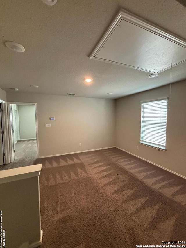 carpeted empty room with a textured ceiling