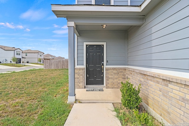 property entrance with a lawn