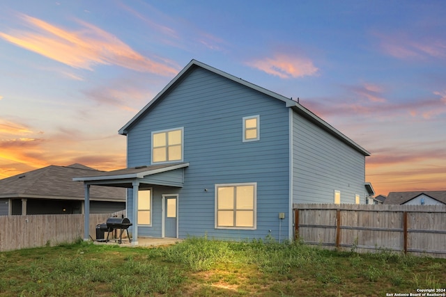 back house at dusk with a patio