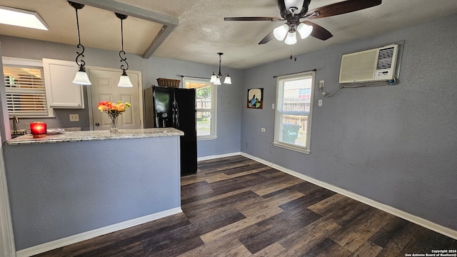 kitchen with white cabinetry, dark wood-type flooring, pendant lighting, ceiling fan, and black fridge