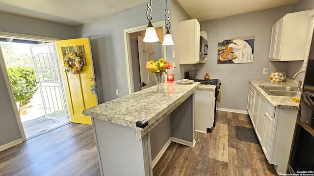 kitchen with dark hardwood / wood-style floors, sink, white cabinets, gas range, and decorative light fixtures