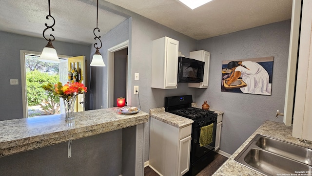 kitchen with hanging light fixtures, sink, a textured ceiling, white cabinetry, and black appliances