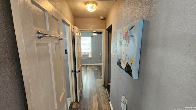 hall featuring cooling unit, a textured ceiling, and dark hardwood / wood-style flooring