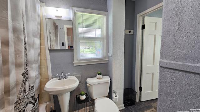 bathroom featuring toilet, a shower with shower curtain, and hardwood / wood-style flooring