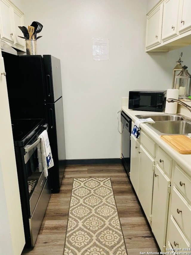 kitchen featuring dark wood-type flooring, black appliances, and sink