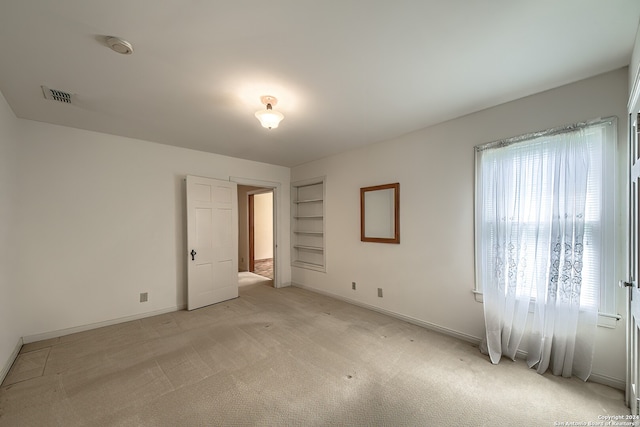 spare room featuring light colored carpet