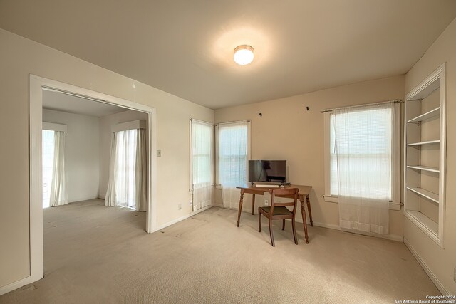 carpeted home office with a healthy amount of sunlight