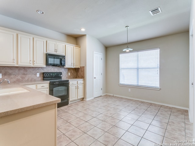 kitchen with hanging light fixtures, black appliances, sink, and light tile patterned floors