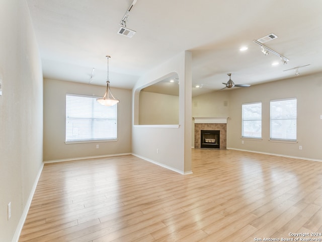 unfurnished living room with light hardwood / wood-style floors, ceiling fan, and track lighting