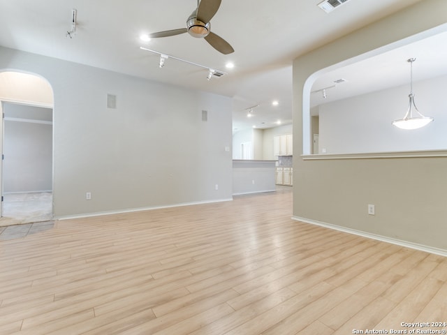 unfurnished room featuring light wood-type flooring, rail lighting, and ceiling fan