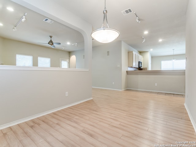 spare room featuring light hardwood / wood-style flooring, ceiling fan, and track lighting