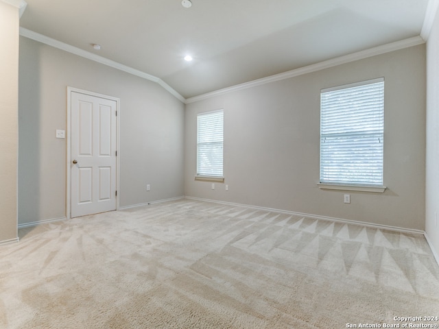 empty room featuring light carpet, lofted ceiling, crown molding, and a healthy amount of sunlight