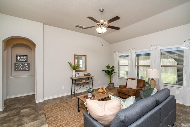 living room featuring a textured ceiling, lofted ceiling, and ceiling fan