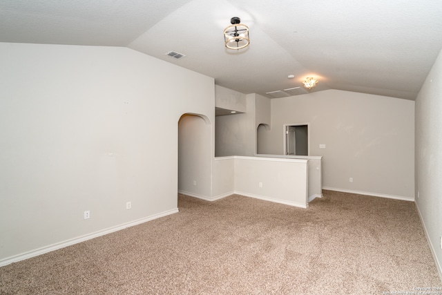 carpeted empty room featuring lofted ceiling