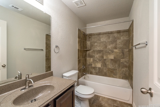 full bathroom with vanity, a textured ceiling, tiled shower / bath combo, tile patterned flooring, and toilet