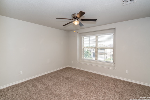 carpeted spare room with ceiling fan