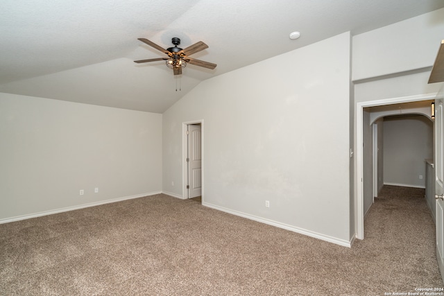 carpeted spare room featuring lofted ceiling and ceiling fan