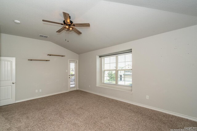 empty room featuring carpet floors, vaulted ceiling, and ceiling fan