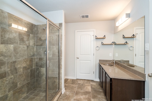 bathroom with a shower with shower door and vanity