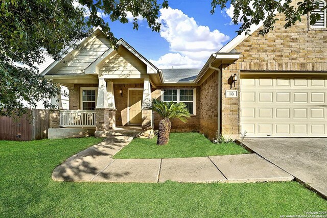 craftsman inspired home with a garage and a front lawn