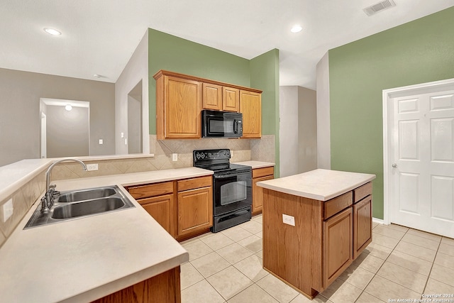 kitchen featuring lofted ceiling, light tile patterned floors, sink, black appliances, and a center island