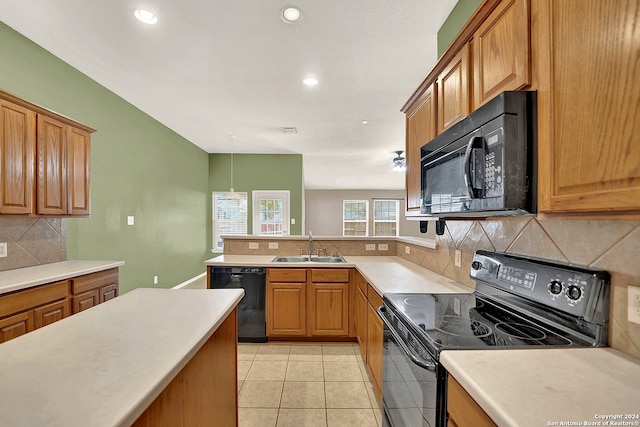 kitchen with light tile patterned flooring, sink, backsplash, black appliances, and decorative light fixtures