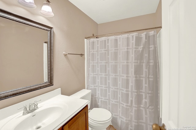 bathroom with vanity, toilet, and curtained shower