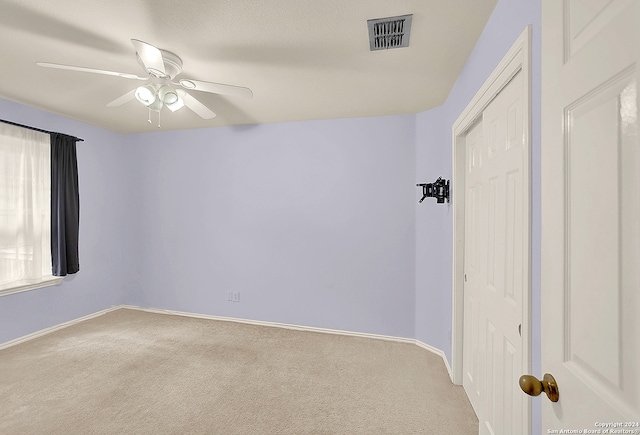 unfurnished room featuring ceiling fan and light colored carpet