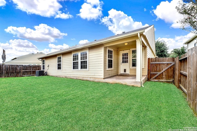 back of property with a patio, cooling unit, and a yard