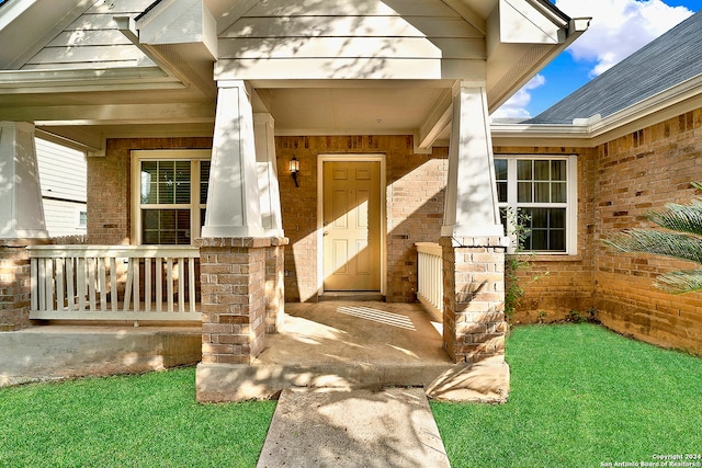 entrance to property with a yard and a porch