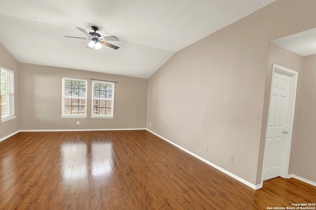 empty room with vaulted ceiling, ceiling fan, and hardwood / wood-style flooring