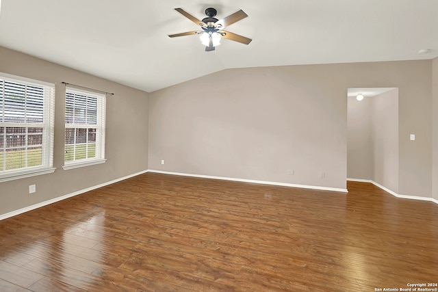 empty room with ceiling fan, vaulted ceiling, and dark wood-type flooring