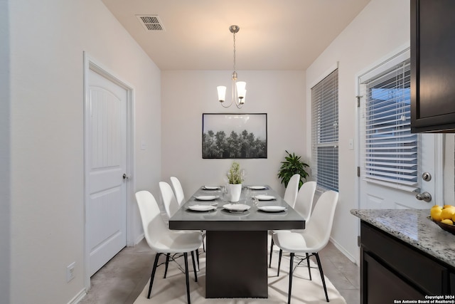 dining room featuring baseboards, visible vents, and a chandelier