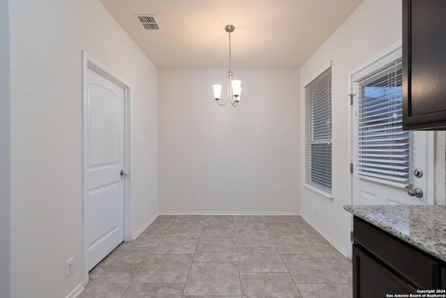 unfurnished dining area with a chandelier, visible vents, baseboards, and light tile patterned floors