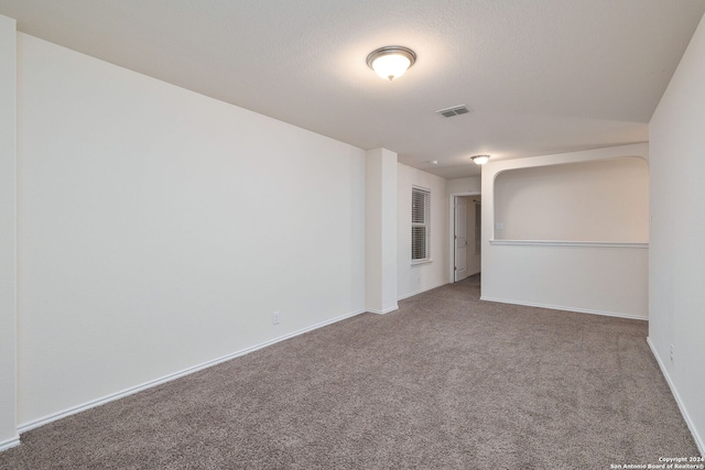 spare room featuring baseboards, visible vents, and carpet flooring