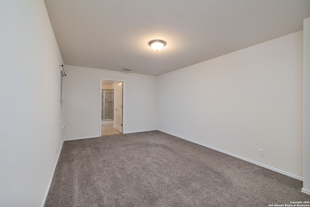 carpeted spare room featuring baseboards and visible vents