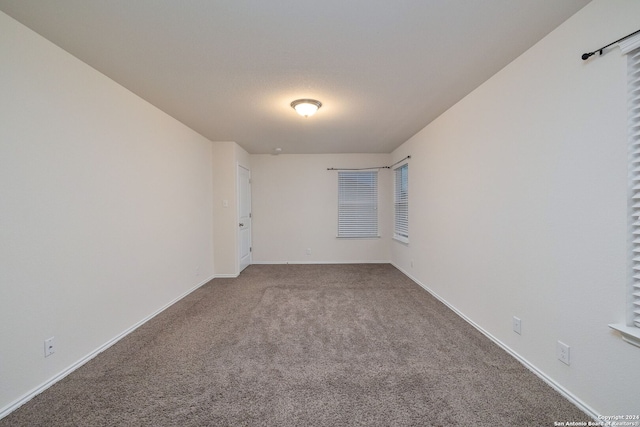 carpeted empty room with baseboards