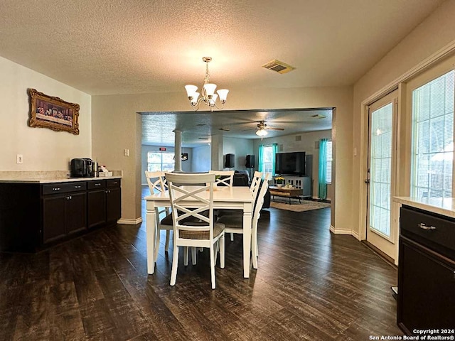 dining room with a textured ceiling, ceiling fan with notable chandelier, and dark hardwood / wood-style floors