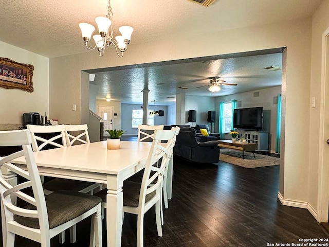 dining room with ceiling fan with notable chandelier, a textured ceiling, and dark hardwood / wood-style floors