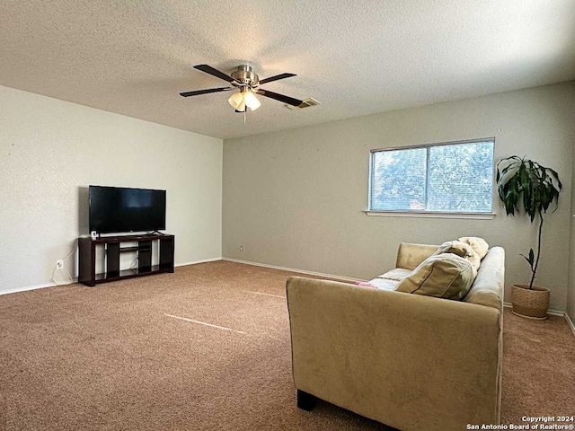 carpeted living room featuring ceiling fan and a textured ceiling