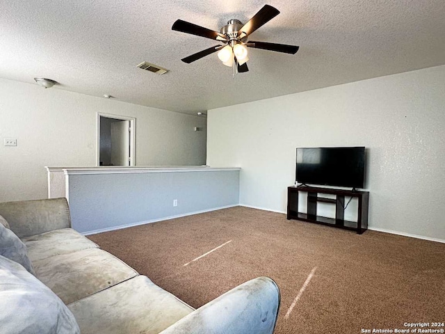 carpeted living room with ceiling fan and a textured ceiling