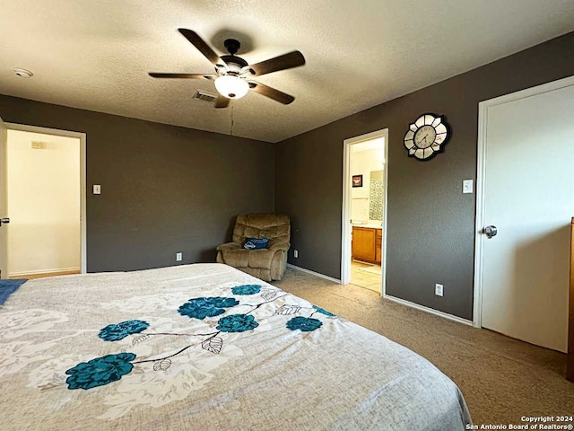 bedroom with a textured ceiling, ensuite bath, ceiling fan, and light colored carpet